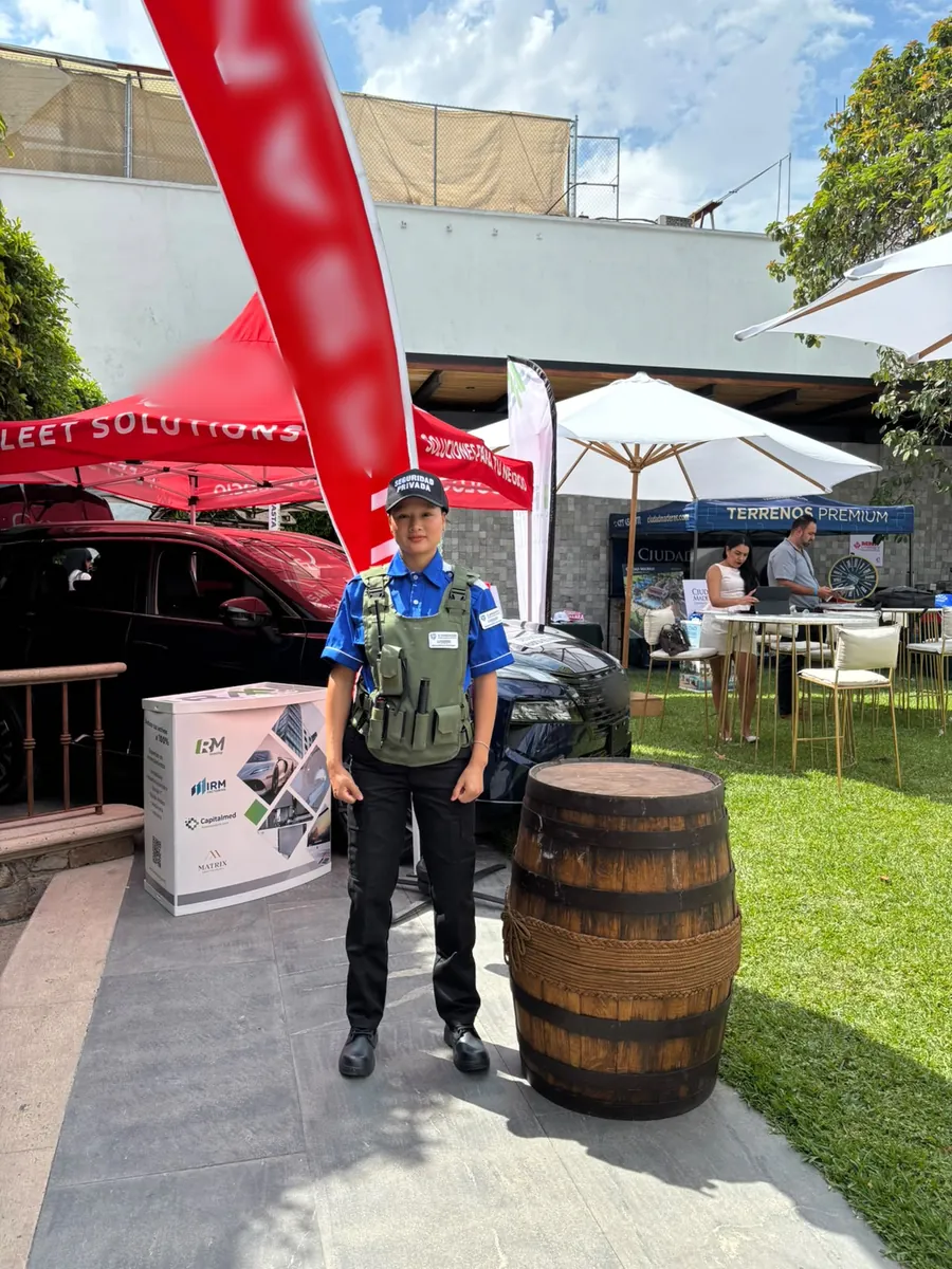 Guardia de Candado en un evento al aire libre, junto a los módulos de los expositores